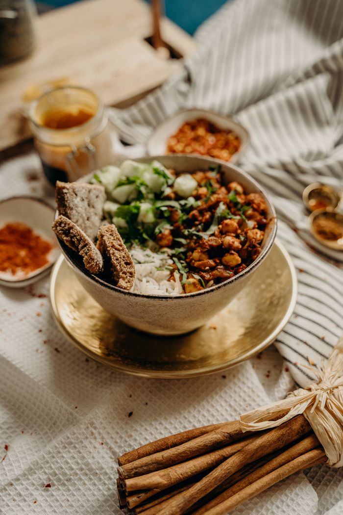 Contact A delicious, healthy vegan bowl featuring chickpeas, rice, cucumbers, and spices. Perfect for a nutritious meal.